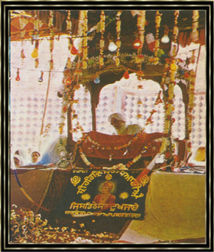 Sikhs drngen sich in einem Zelt in Neu-Delhi. Unter dem Baldachin liest ein Priester aus den heiligen Schriften. Das Bild zeigt den Grnder der Sikhs-Religion, Nanak,der die Hindus und Moslems einigen wollte.
